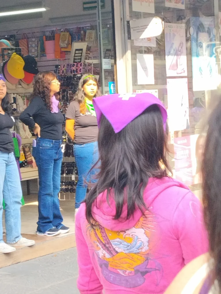 trabajadoras de comercios observan la marcha 8M Puebla en el centro histórico