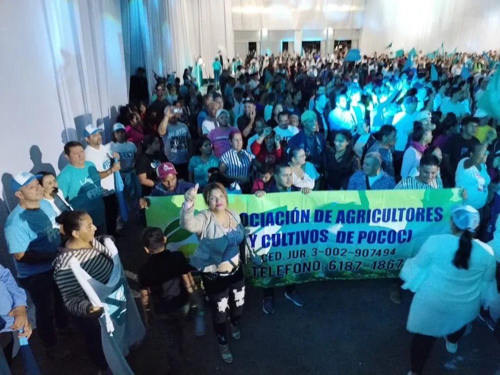 Agricultores de Pococí en actividad con pancarta de la asociación durante evento político